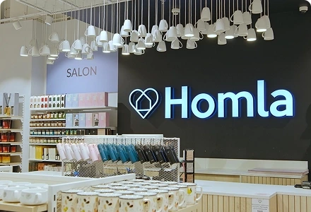 Wnętrze salonu HOMLA z logo marki i ekspozycją produktów